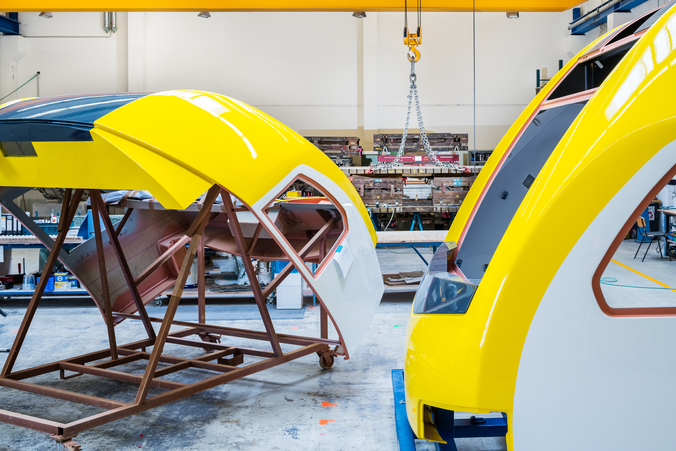 Pruduktion in der RCS GmbH in Königsbrück Blau und gelb gespritzte Metallteile einer Zugspitze trocknene auf Gestellen.