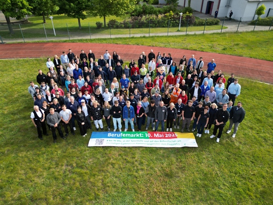 Menschenansammlung und ein Banner vom Berufemarkt