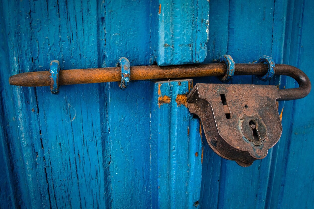 ein Türschloss vor einer blauen Holzwand