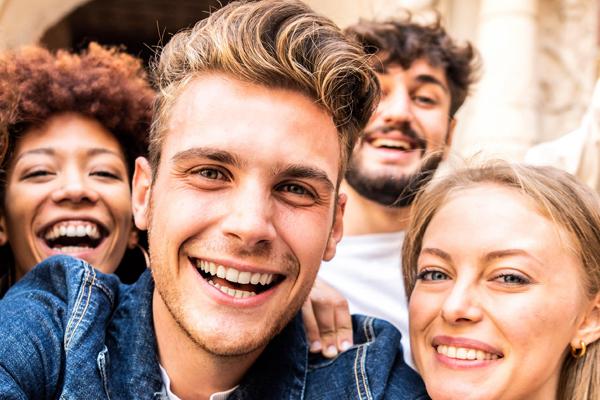 zwei junge Frauen und zwei junge Männer lächeln