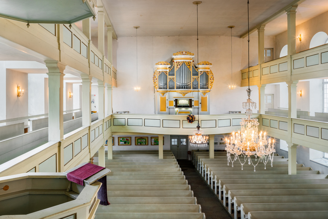 Die Abbildung zeigt einen Kirchenraum mit Blick auf die Orgel.