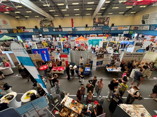 Blick in eine Messehalle mit Besuchern