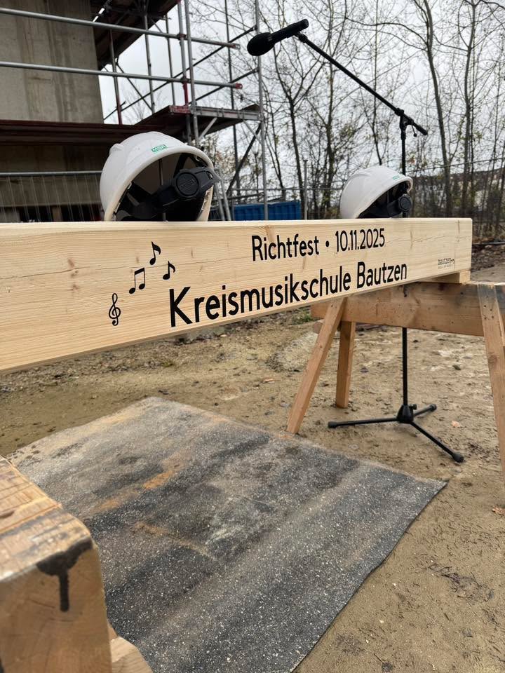 Das Bild zeigt ein Holzschild, auf welchem das Datum des Richtfests notiert ist