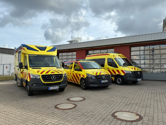 drei Rettungsfahrzeuge vor Garagen