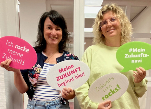 zwei Frauen mit Schildern in der Hand