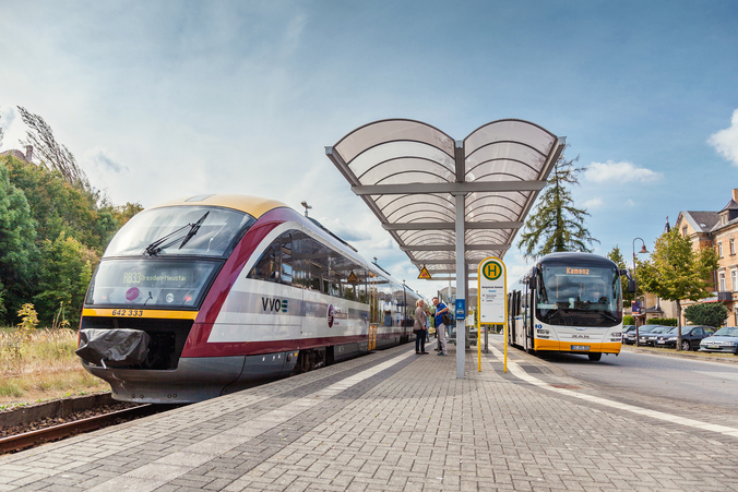 Übergangshaltestelle in Königsbrück An einer Übergangshaltestelle steigen Menschen aus einem Bus in einen Zug um.