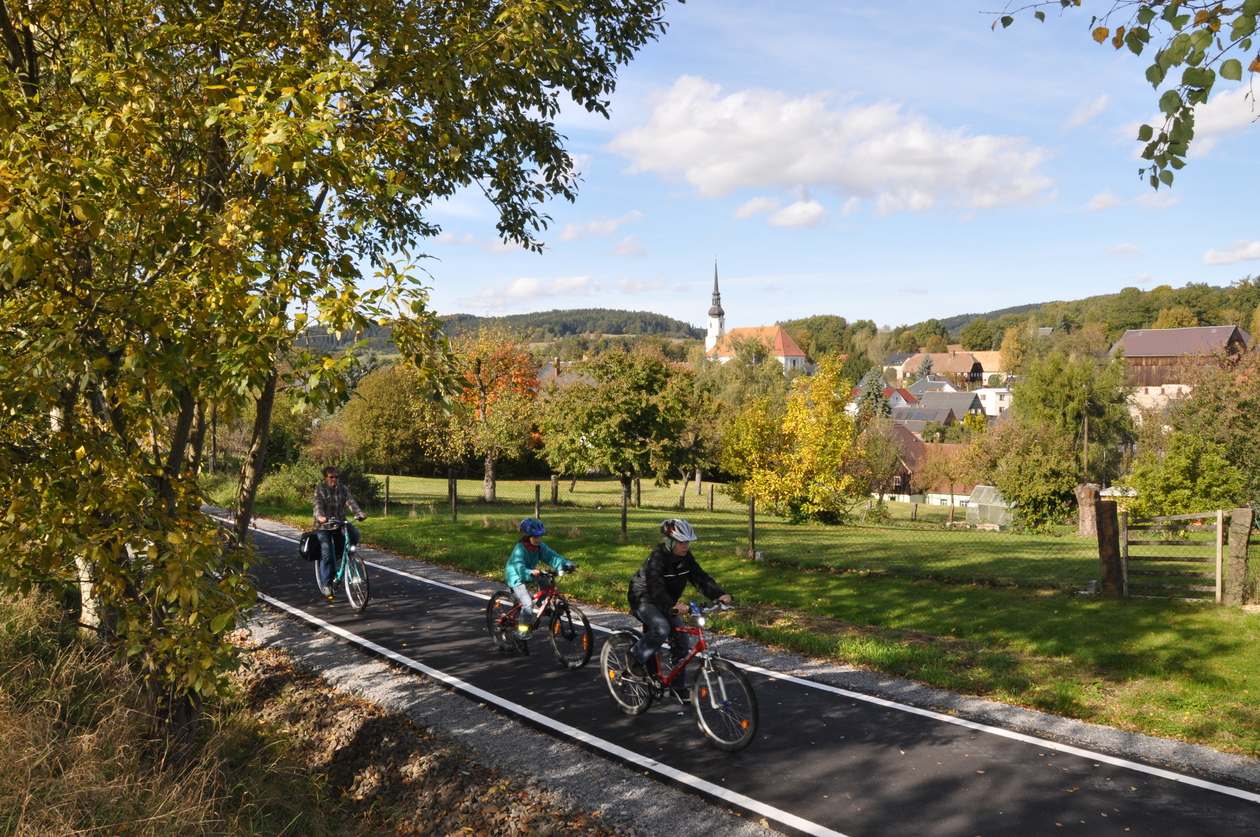 Eine Frau und zwei Kinder radeln auf dem Bahnradweg Oberlausitz.