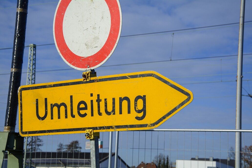 Buslinien 513, 514 und 729 werden umgeleitet Im Vordergrund zwei Schilder, Durchfahrt verboten, Umleitung