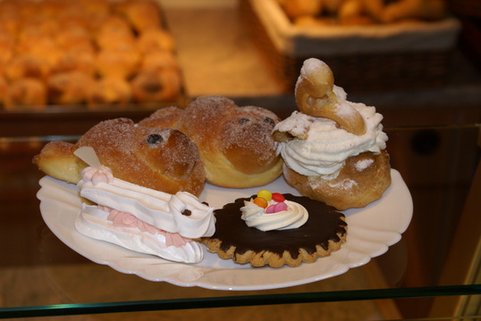 Das Foto zeigt das typische Gebäck zur Vogelhochzeit: Teigvögel und Cremenester.