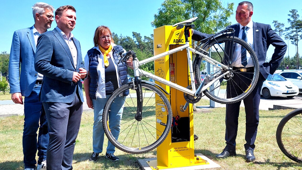 drei Männer, eine Frau an einer ADAC Fahrradstation