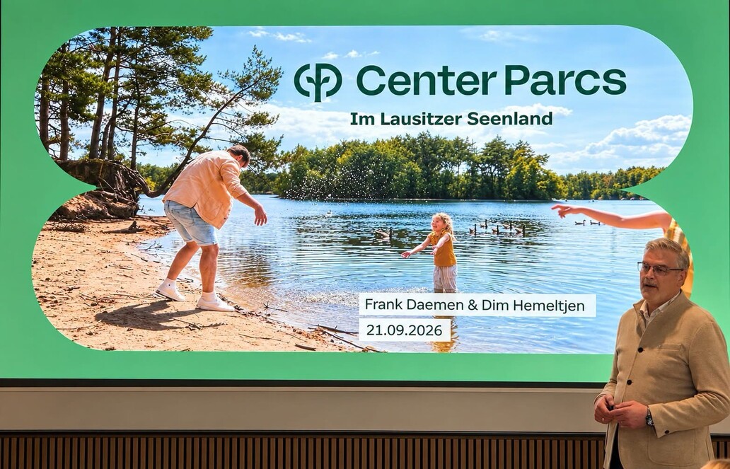 Mann steht vor Leinwand mit Vortrag über Center Parks im Lausitzer Seenland 