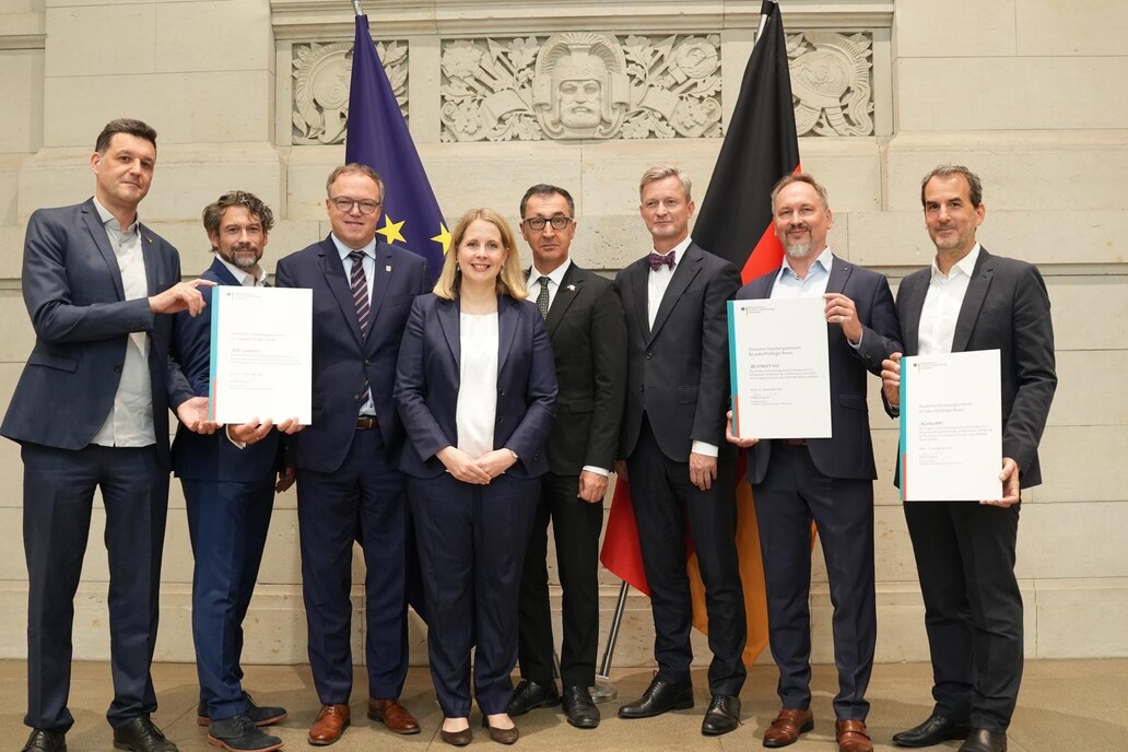 Bundesbauministerin Verena Hubertz den drei Gründungsmitgliedern des Deutschen Forschungszentrums 