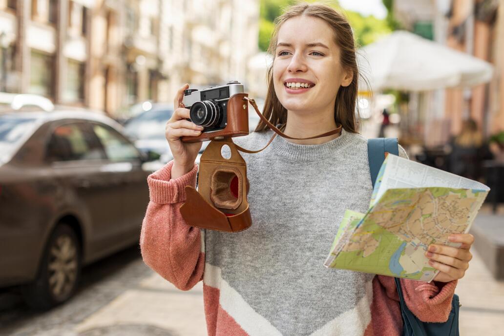 eine junge Frau mit einem Fotoapparat und einem Stadtplan 